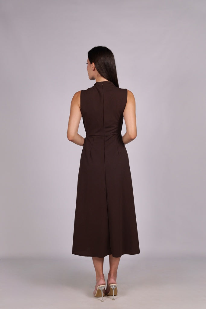 Modella con abito marrone a gonna midi, senza maniche, nodo al petto, outfit elegante.