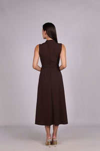 Modella con abito marrone a gonna midi, senza maniche, nodo al petto, outfit elegante.
