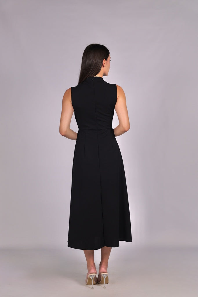 Modella con abito nero a gonna midi, senza maniche, nodo al petto, outfit chic.