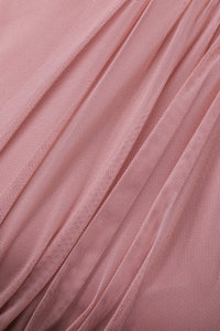 Modella con abito rosa a gonna lunga, collo a imbarcatura, foulard in tulle trasparente, outfit elegante per eventi speciali.