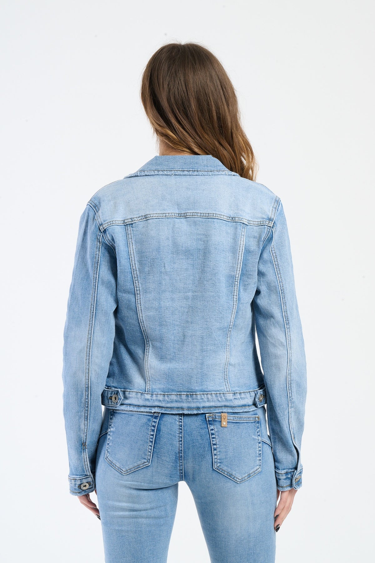 Modella con giacca di jeans e top bianco, stile urban e trendy.