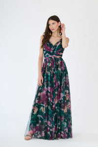 Modella in abito maxi verde scuro con stampa floreale, spalline sottili e apertura laterale