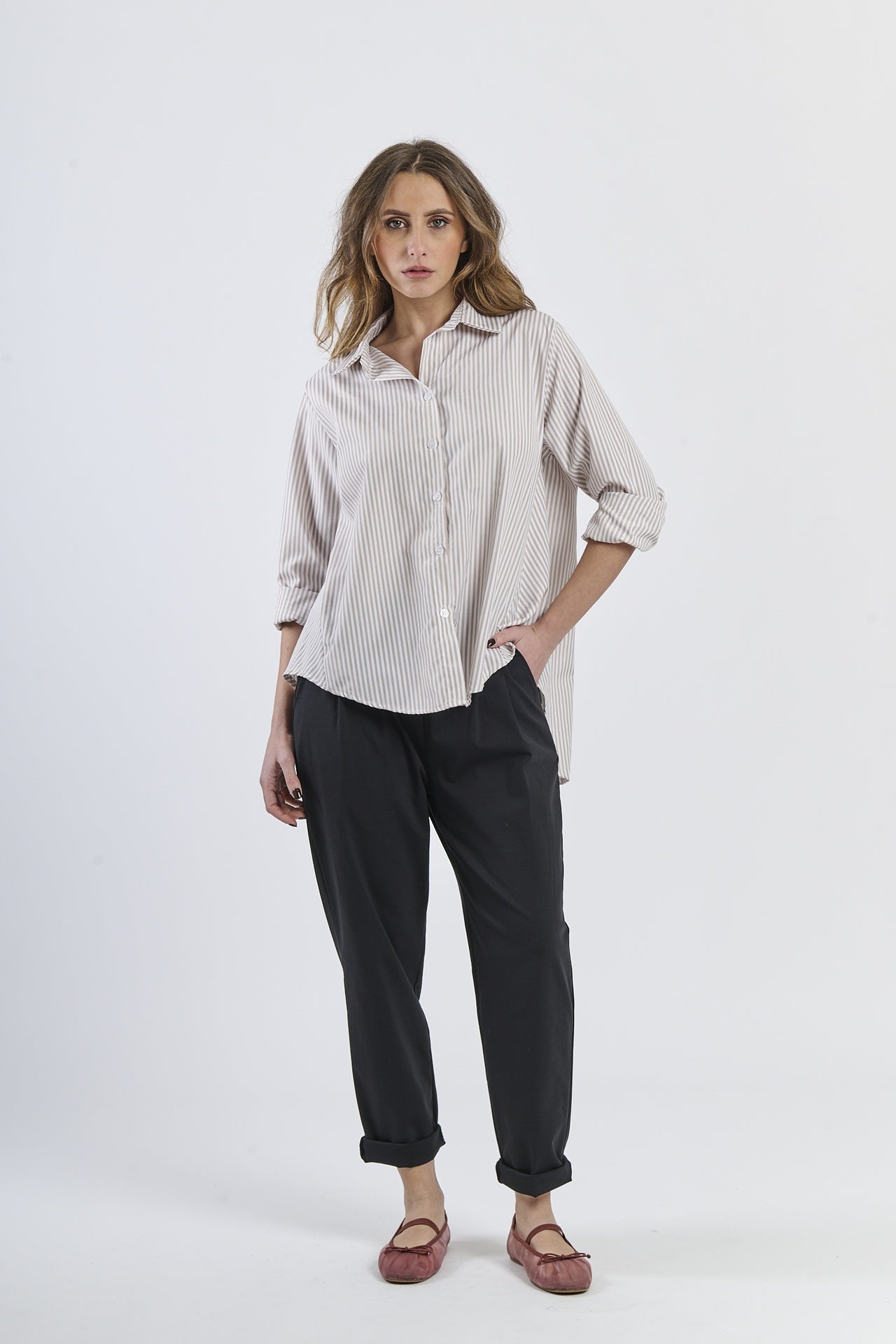 Modello in camicia beige a righe, abito comodo e moderno