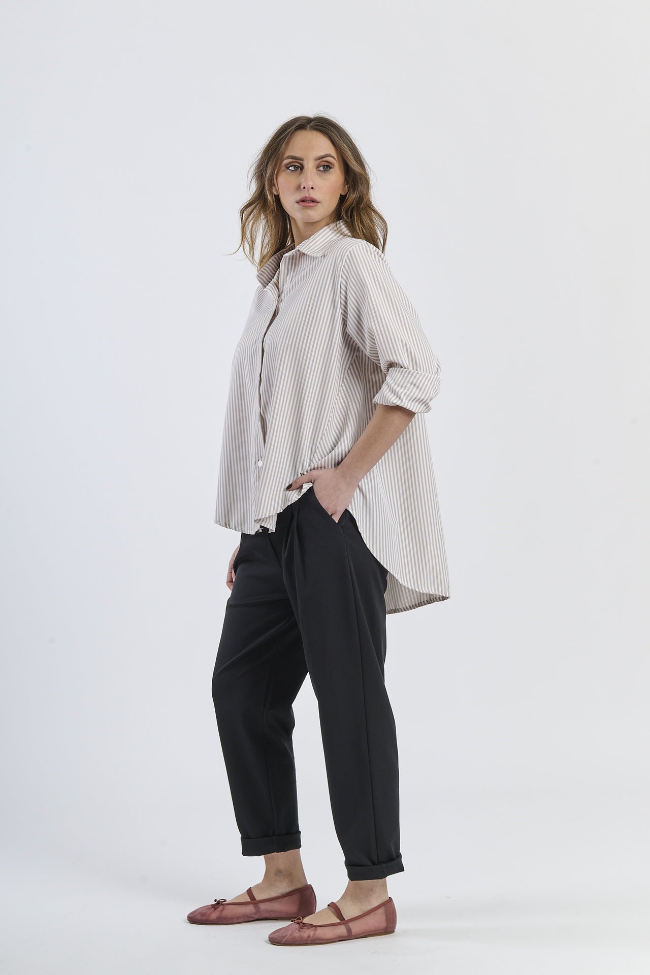 Modello in camicia beige a righe, abito comodo e moderno