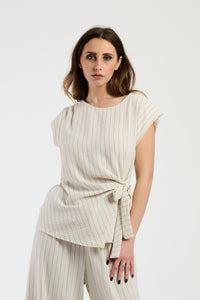 Outfit beige composto da top e pantaloni, stile classico e versatile.