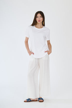 Outfit bianco minimalista: t-shirt e pantaloni larghi su una persona