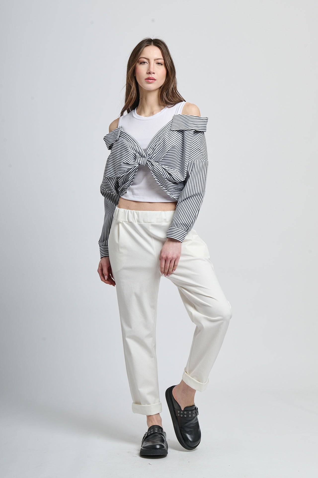 Outfit casual con giacca a righe nera e pantaloni bianchi, stile urbano