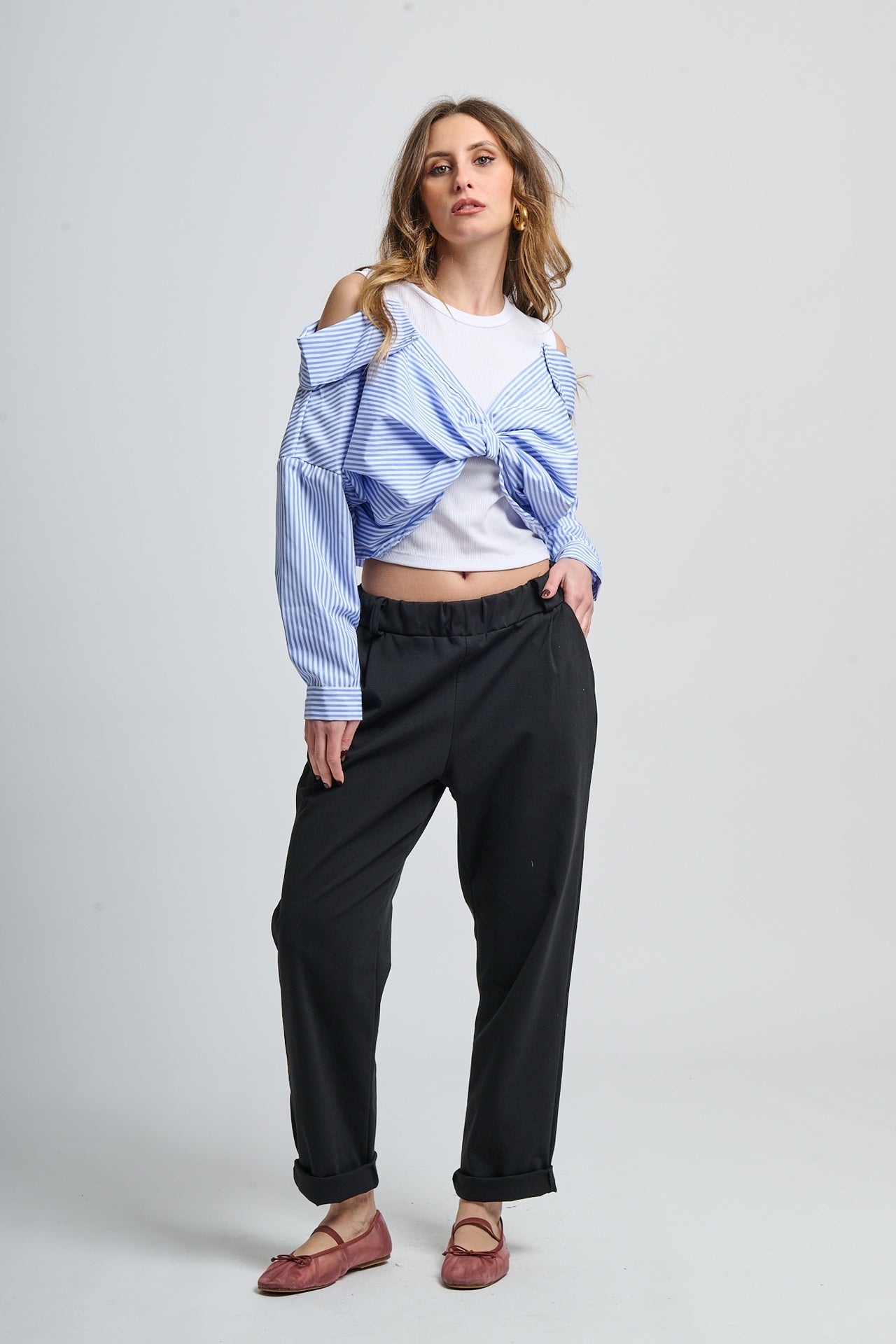 Outfit casual con giacca a righe azzurra e pantaloni scuri, stile daily