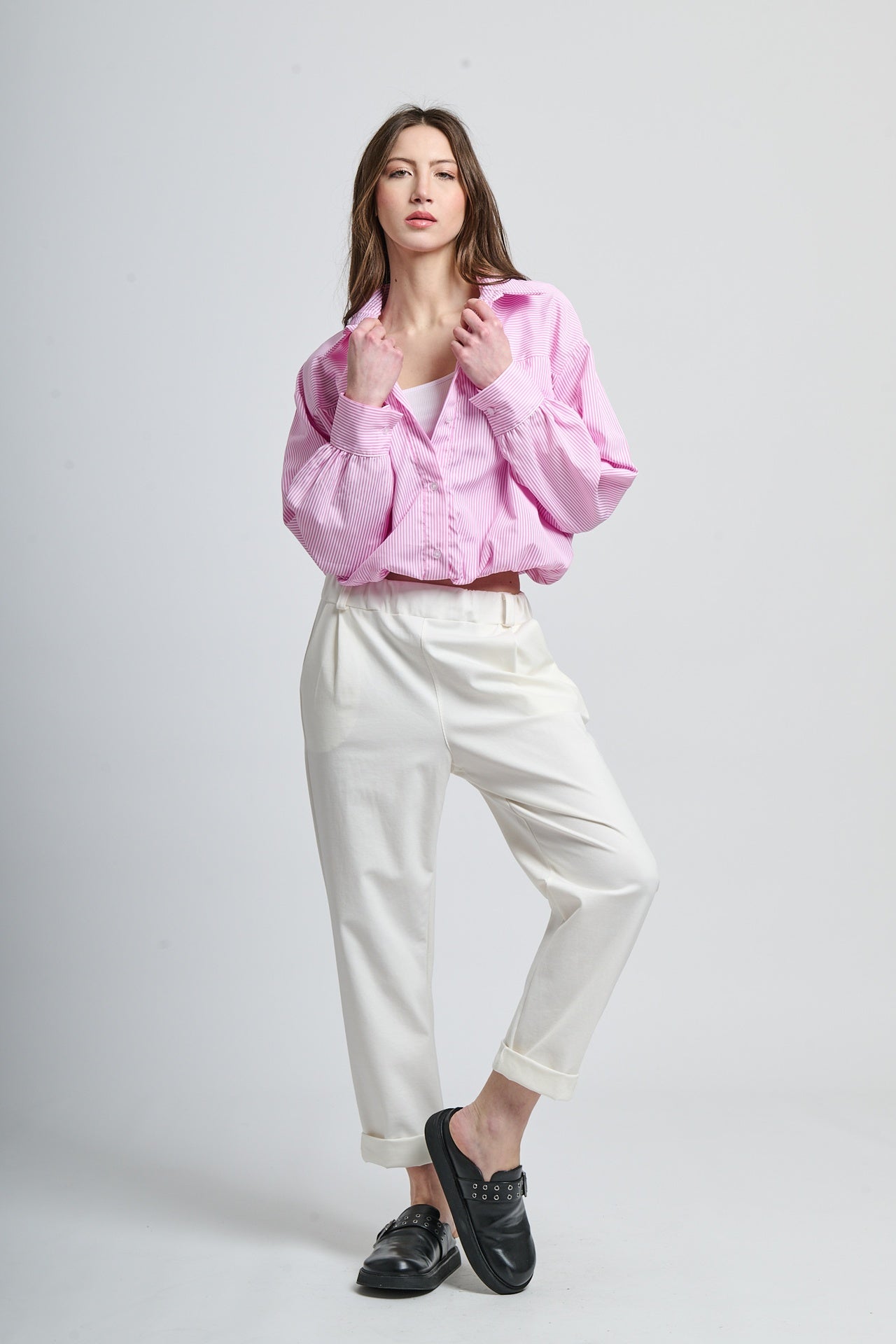 Outfit casual con camicia rosa a righe e pantaloni bianchi