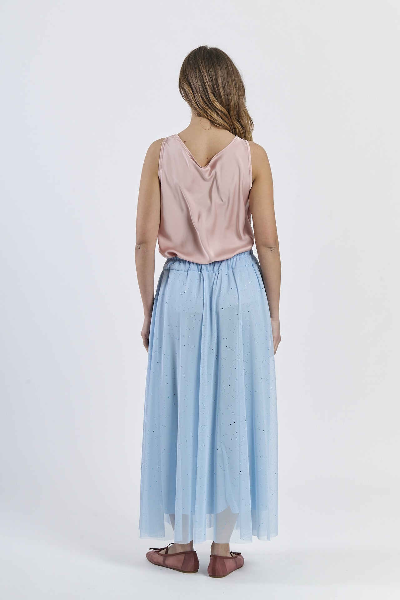 Outfit con gonna azzurra e top a scollatura drapata