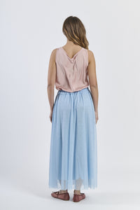 Outfit con gonna azzurra e top a scollatura drapata