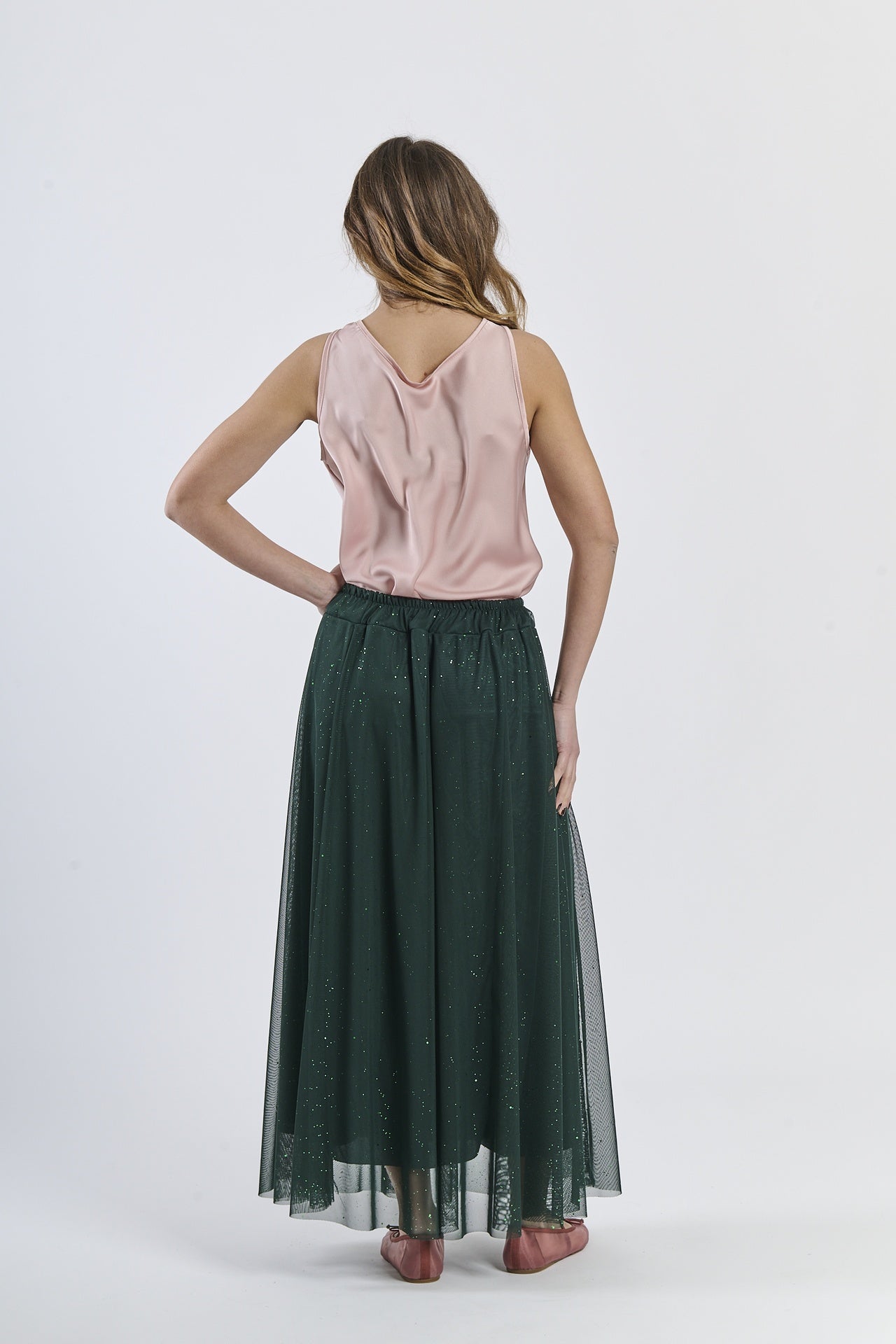 Outfit con gonna verde scuro e top a scollatura drapata