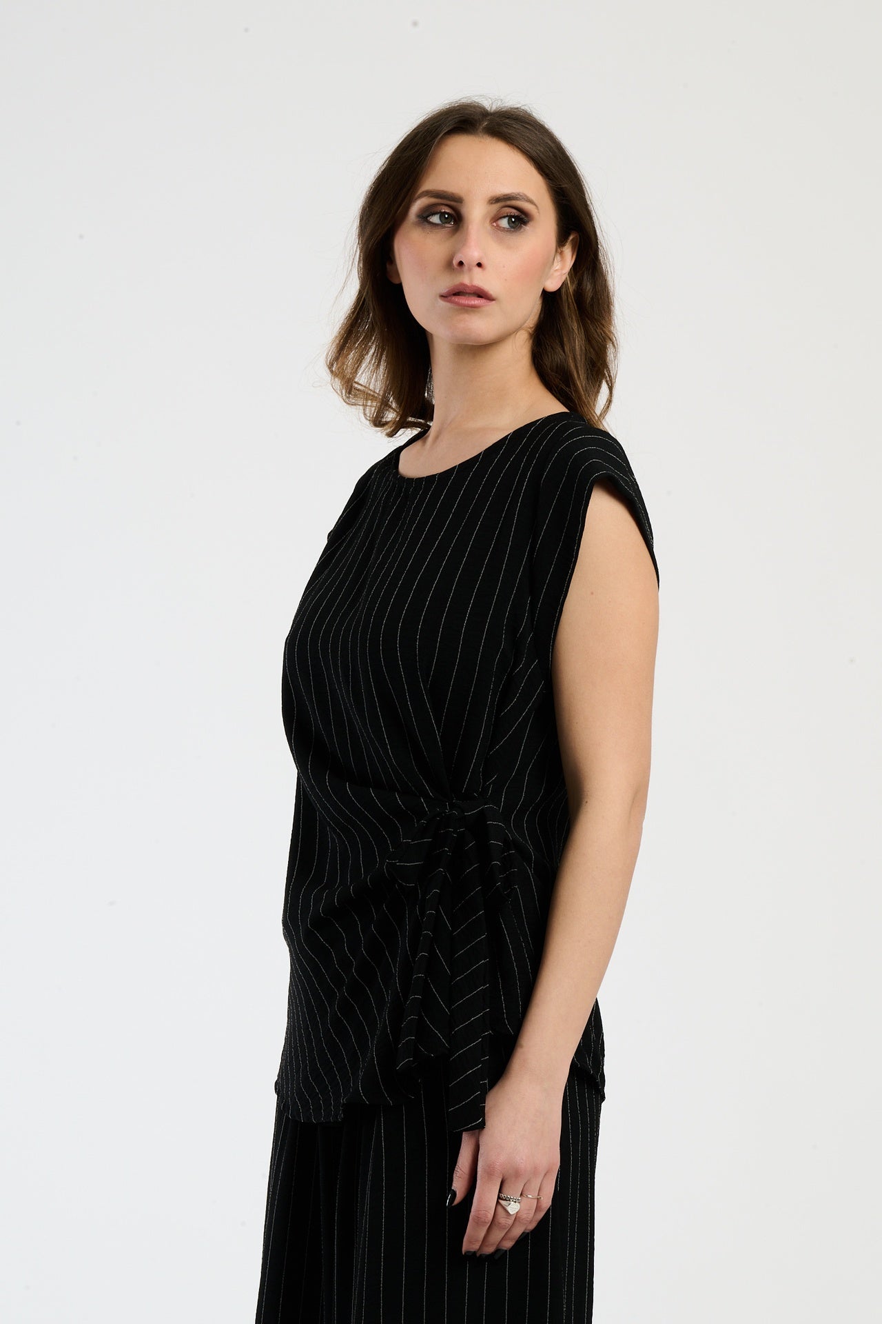 Outfit nero composto da top e pantaloni, stile minimale e seducente.