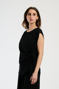 Outfit nero composto da top e pantaloni, stile minimale e seducente.