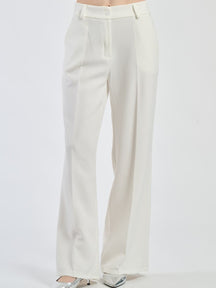 Pantaloni larghi bianchi con pieghe frontali, luminosità e purezza stilistica.
