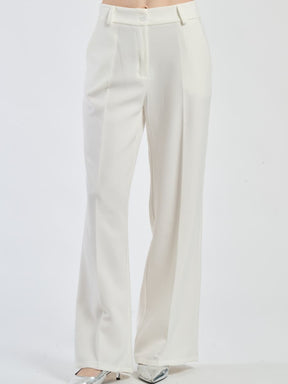 Pantaloni larghi bianchi con pieghe frontali, luminosità e purezza stilistica.