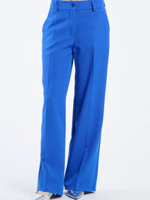 Pantaloni larghi bluette con pieghe frontali, tonalità delicata e rassicurante.