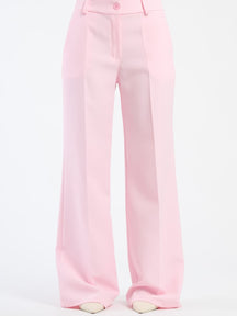 Pantaloni larghi rosa baby con pieghe frontali, dolcezza e femminilità.