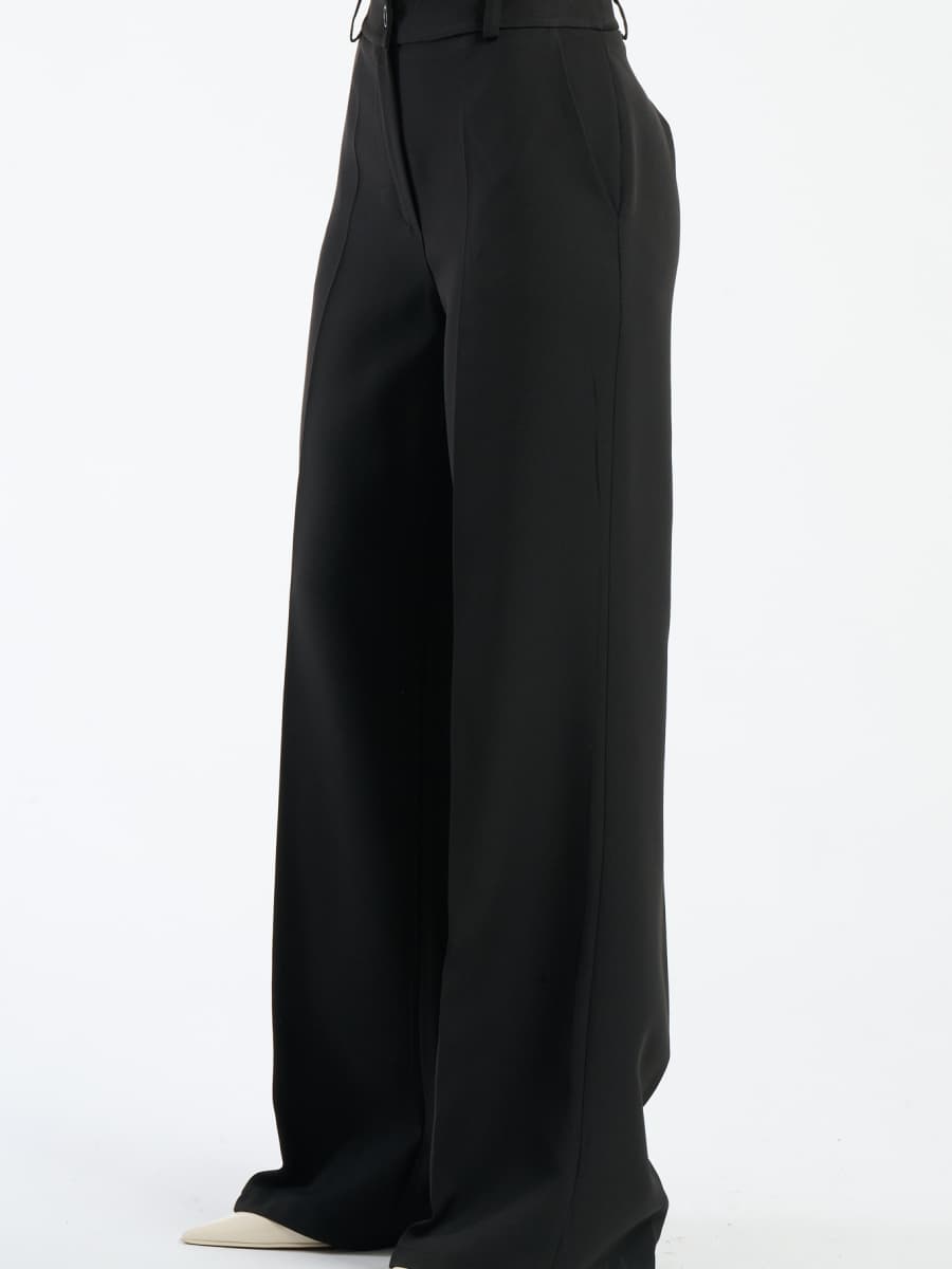 Pantaloni neri fluidi con chiusura a bottoni, potenza e comfort.