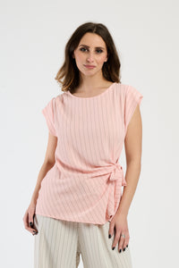 Set rosa su donna: top senza spalline e pantaloni, dolcezza e femminilità.