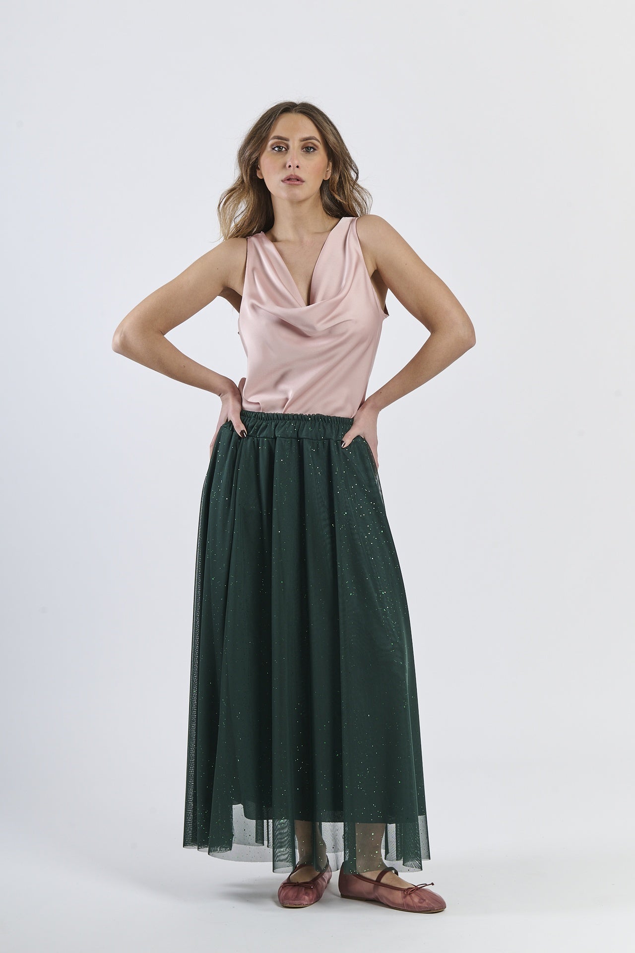 Top rosa e gonna verde scuro, contrasto accattivante