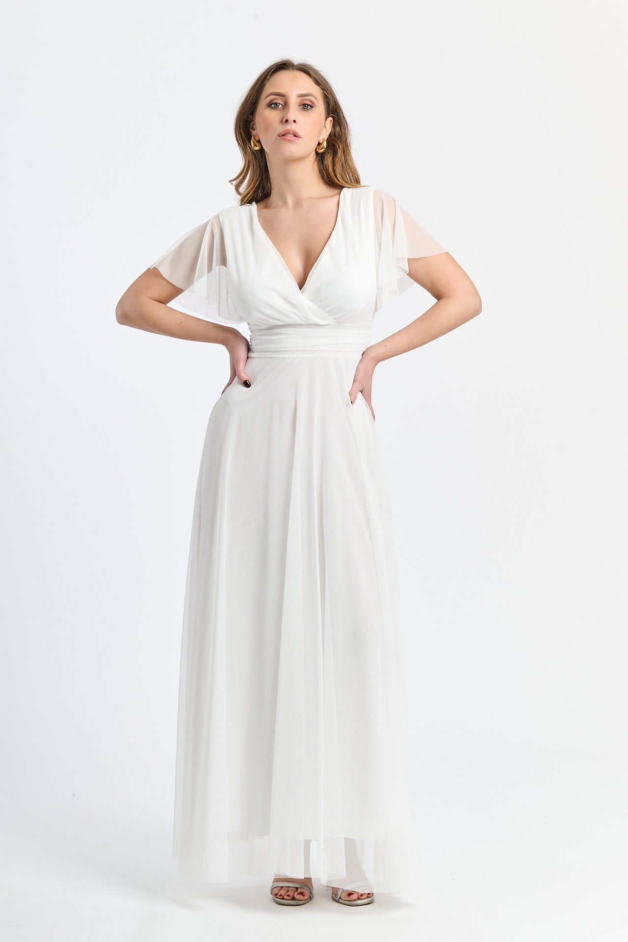 Tulle bianco luminoso, scollo profondo, maniche ruffle, atmosfera raffinata