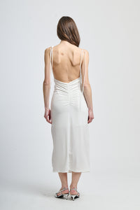 Vestito bianco a corpo con dettagli in raso, dando un tocco di lusso.