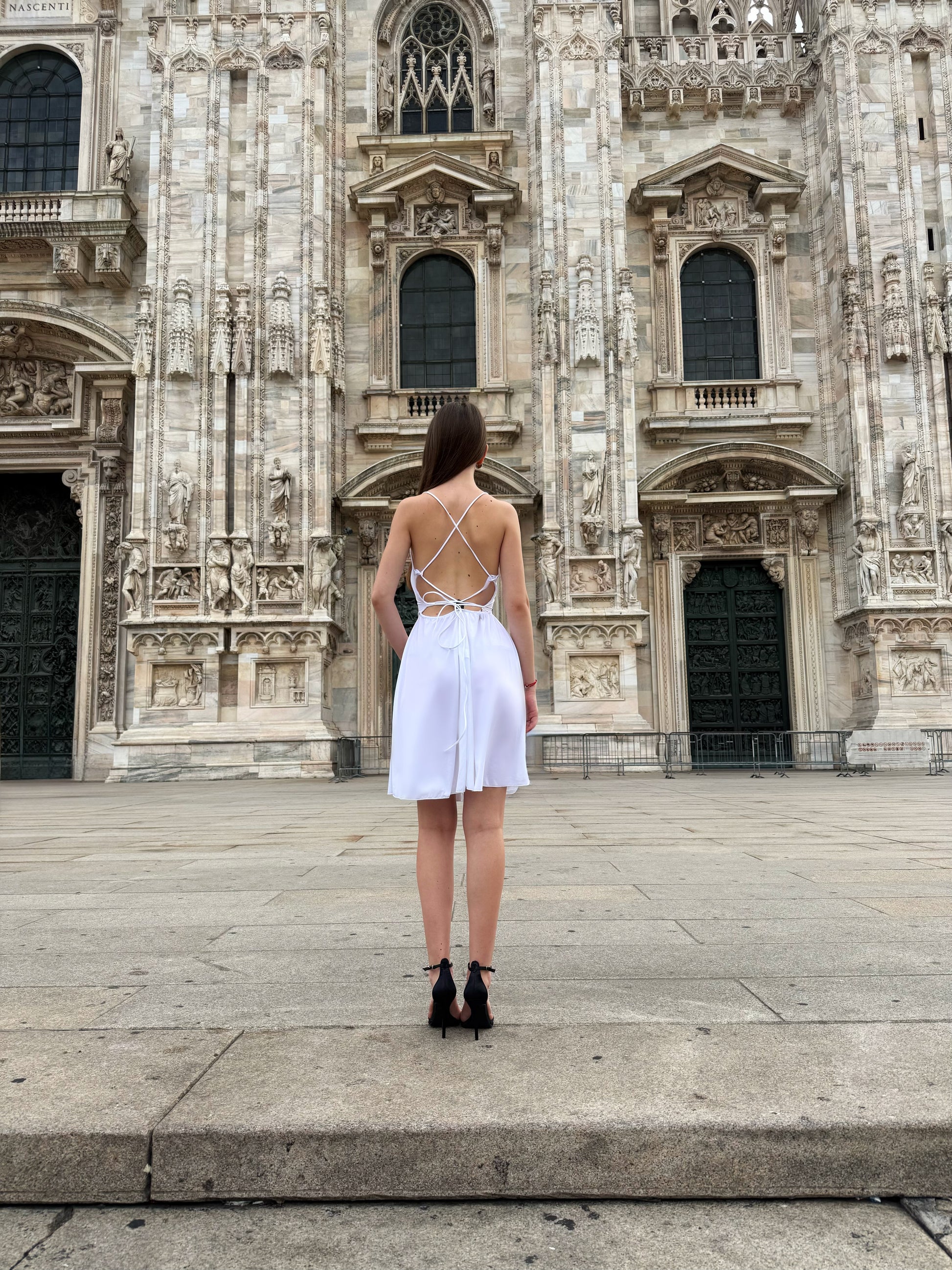 Vestito bianco a spalline sottili e il Duomo di Milano come sfondo