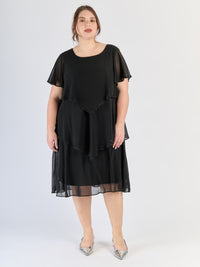 Vestito nero con pannelli sovrapposti, maniche corte traslucide e stile sobrio