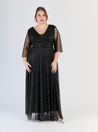 Vestito nero fluido in tulle, fascia sulla vita e maniche semi - trasparenti, classico e affascinante.