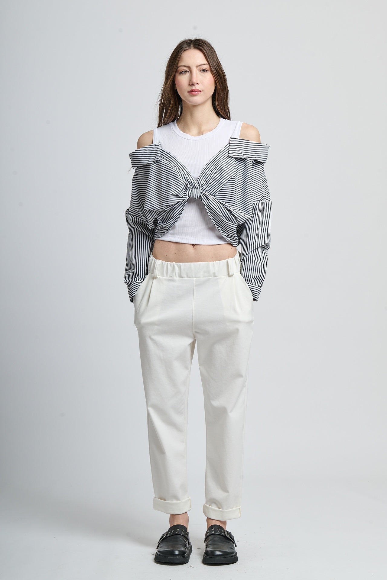 Combinazione di giacca a righe nero e top bianco, look moderno e versatile