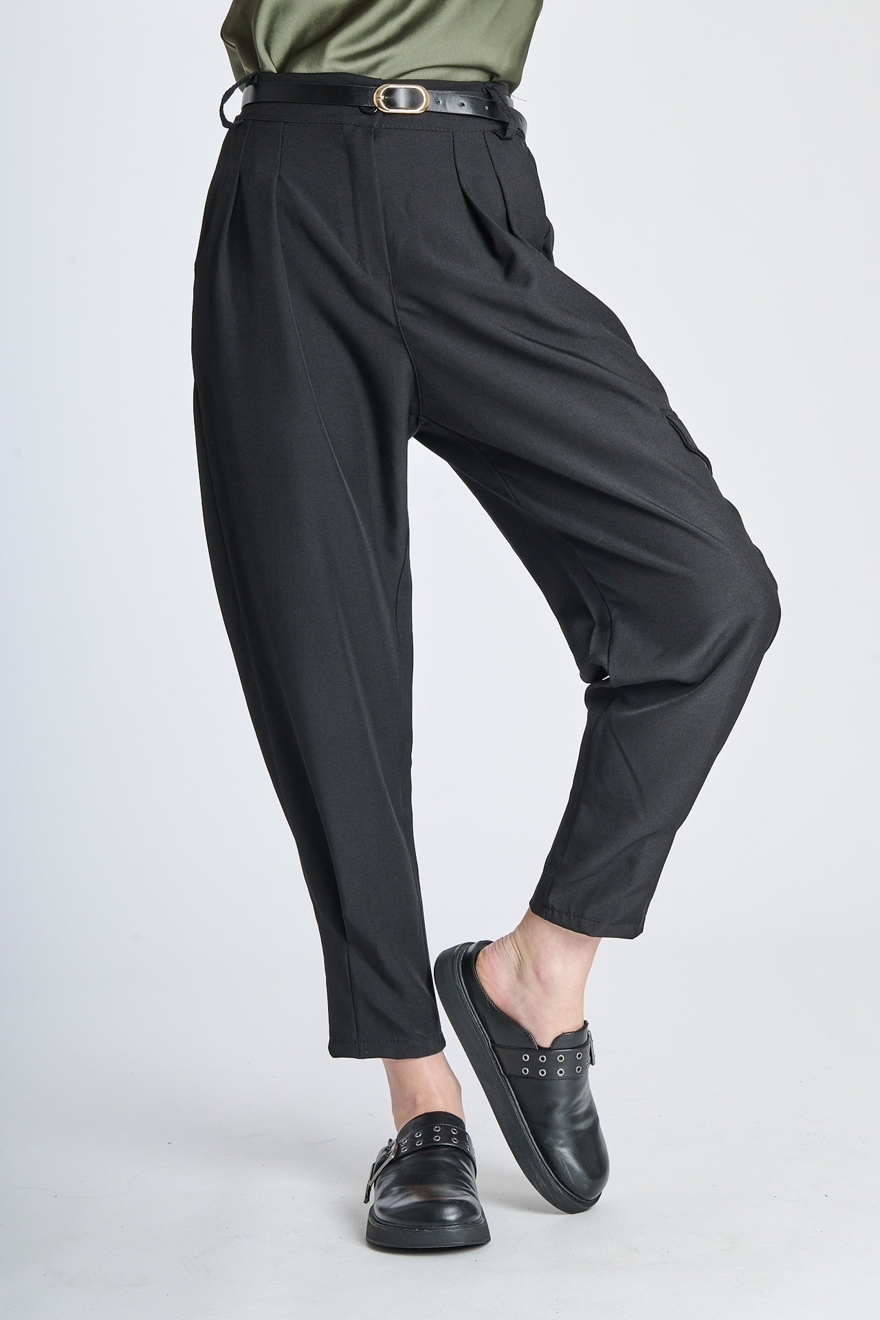 Pantaloni neri con coulisse alta, abbinati a mocassini e top verde