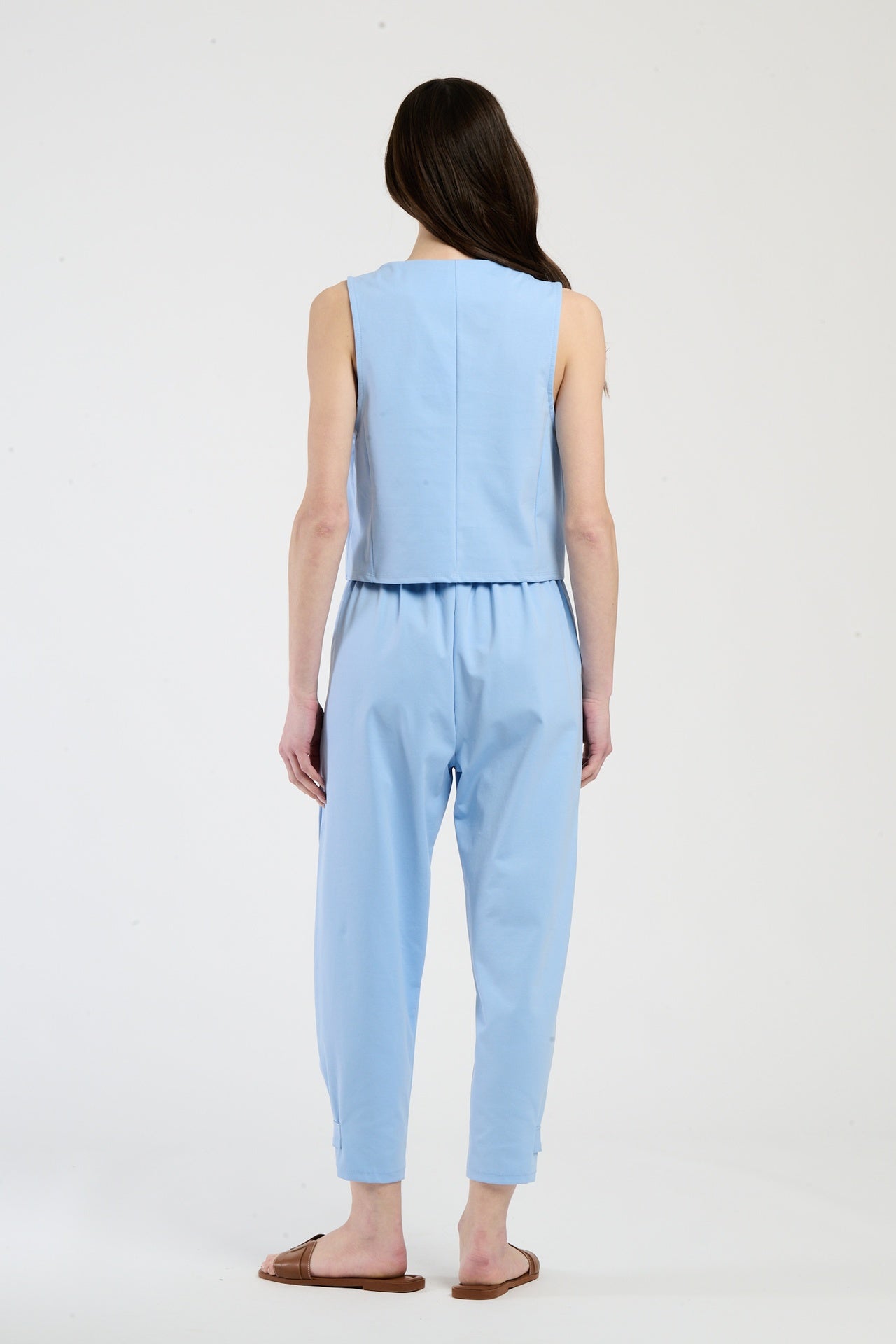 Completo azzurro su una modella: gilet a bottoni e pantaloni, combinazione fresca e accattivante.