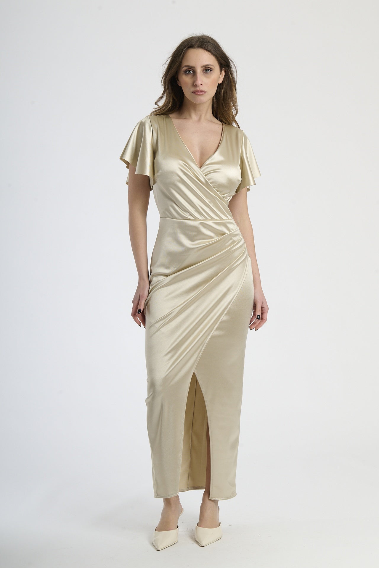 Donna con abito beige in velluto, calore neutro e eleganza rassicurante.