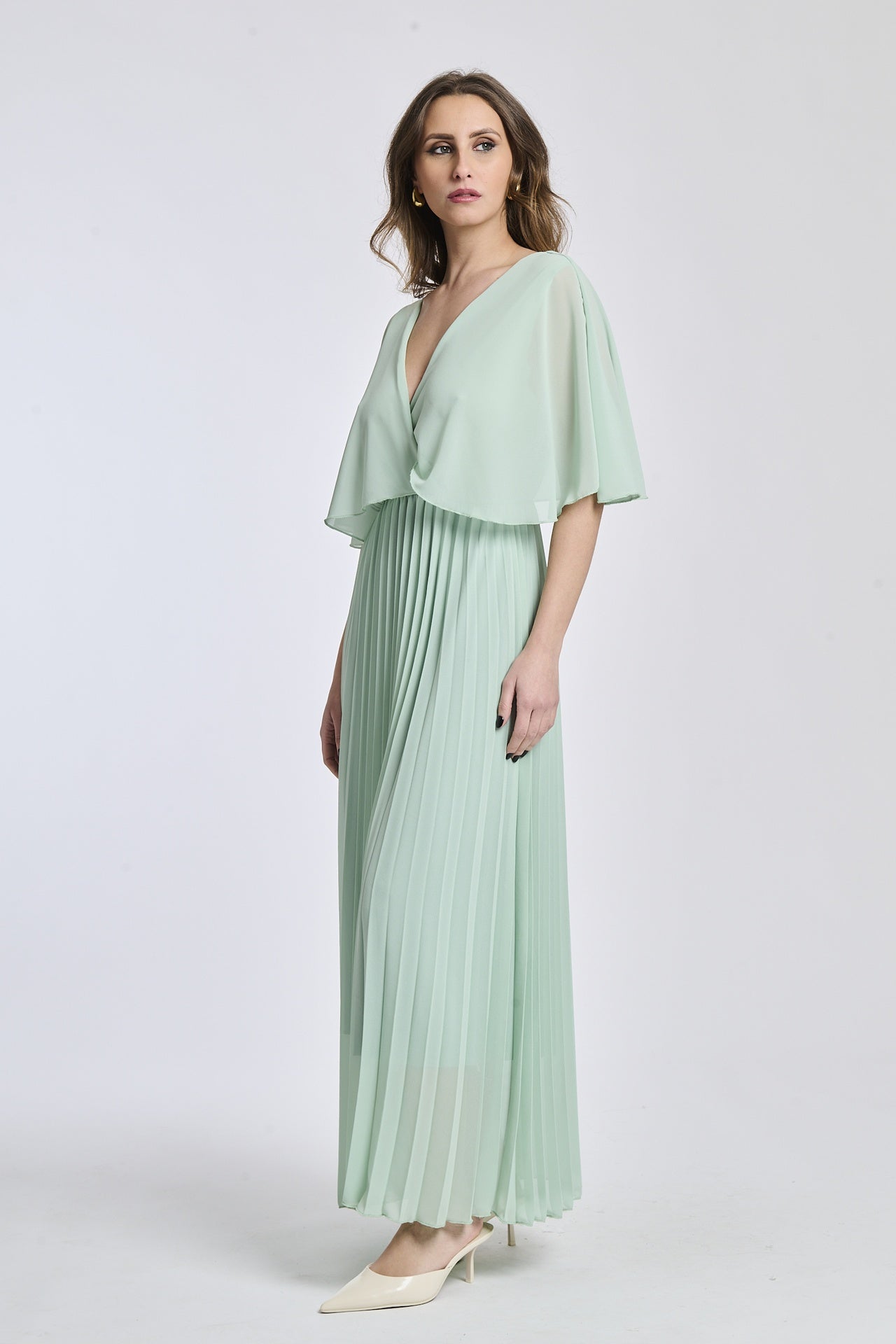Vestito in tono salvia chiaro con dettagli di falde e maniche, offrendo un look moderno e accattivante.