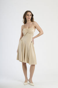 Abito beige con plissé sul busto, abbigliamento elegante e delicato.
