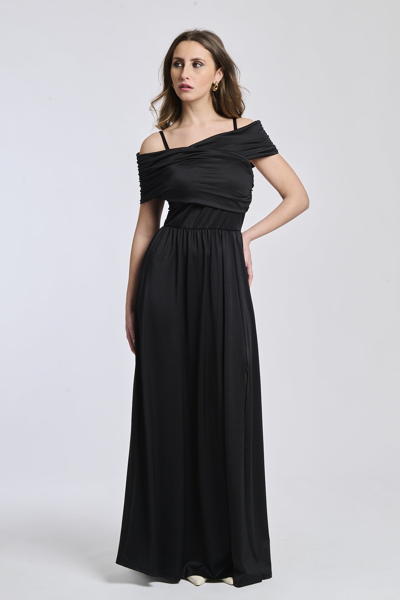 Vestito nero elegante, spalline scollate, maniche assenti, apertura laterale per uno stile sexy.