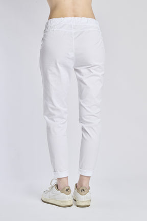 Pantaloni jogger bianchi con coulisse, stile minimalista, abbinati a sneaker bianche