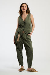 Donna con completo colore militare: gilet e pantaloni, stile ruvido e dal carattere distintivo.