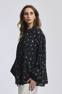 Outfit chic: Camicia nera stampata con collo a imbuto, abbinata a un gonna argento brillante.