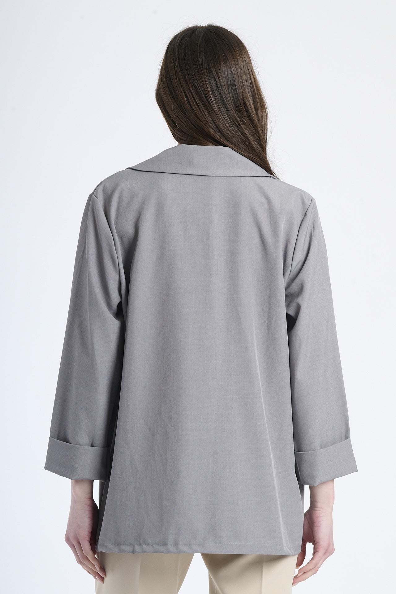 Modella indossa blazer grigio, stile sobrio ed accattivante.