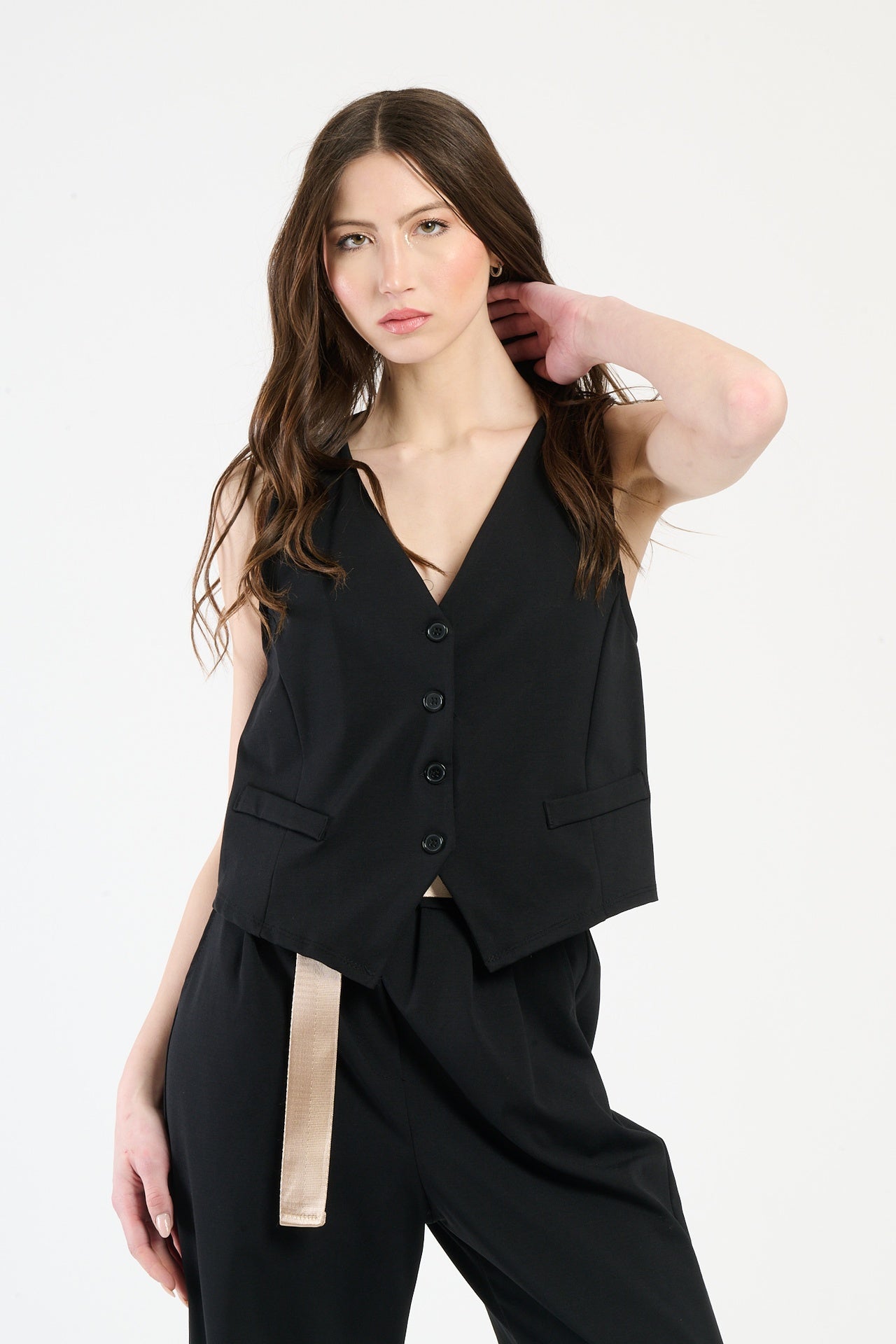 Completo nero su una modella: gilet a bottoni e pantaloni, combinazione classica e accattivante.