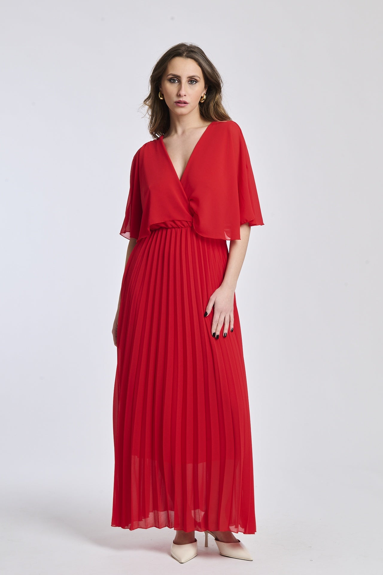 Un vestito in rosso intenso, con la croce sul busto e le maniche a mantello come il modello mostrato, che dà un senso di passione e audacia.