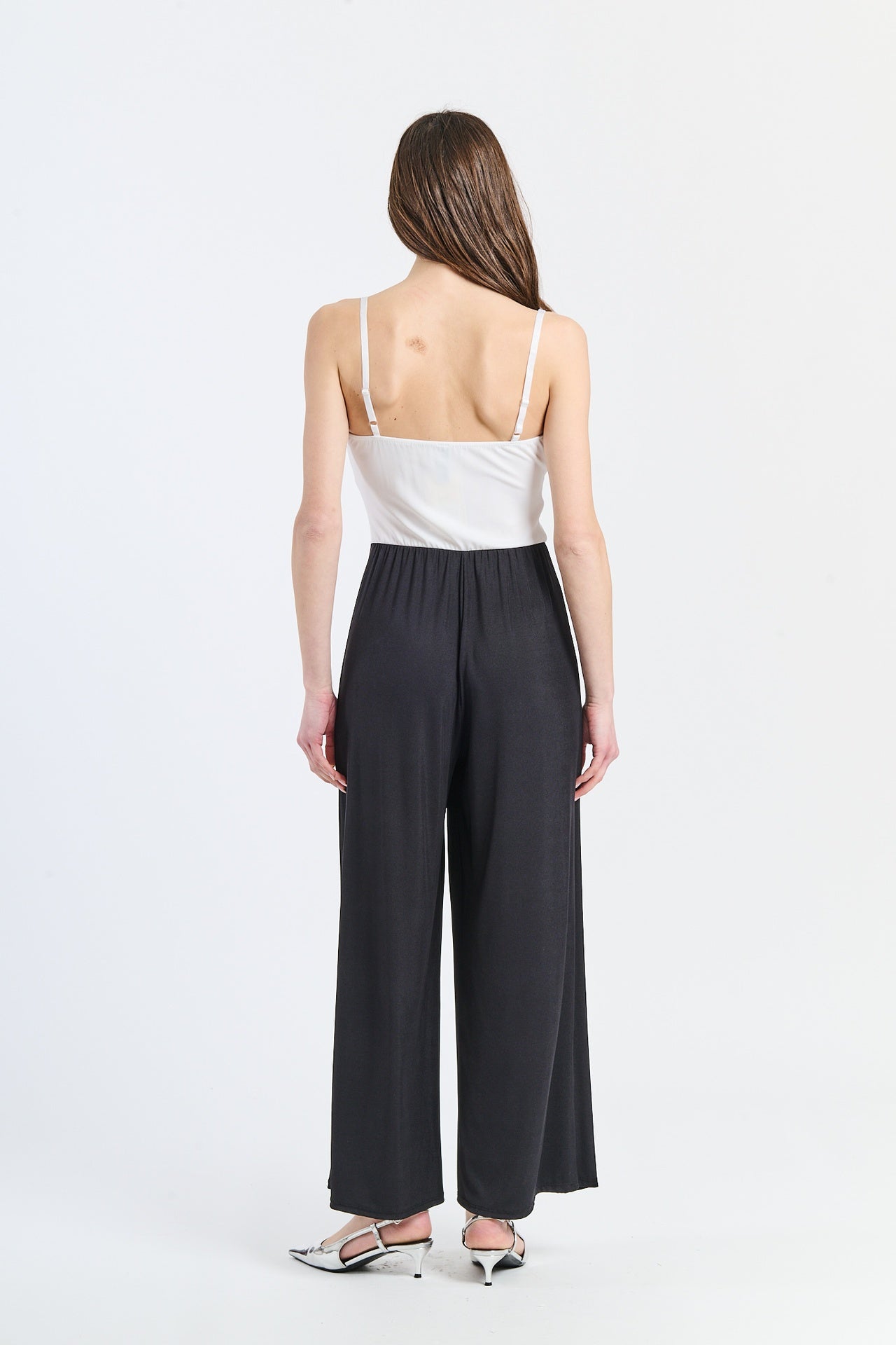 Tuta elegante bianca con nodo decorativo e finitura pulita