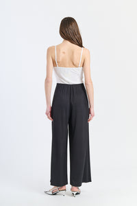 Tuta elegante bianca con nodo decorativo e finitura pulita