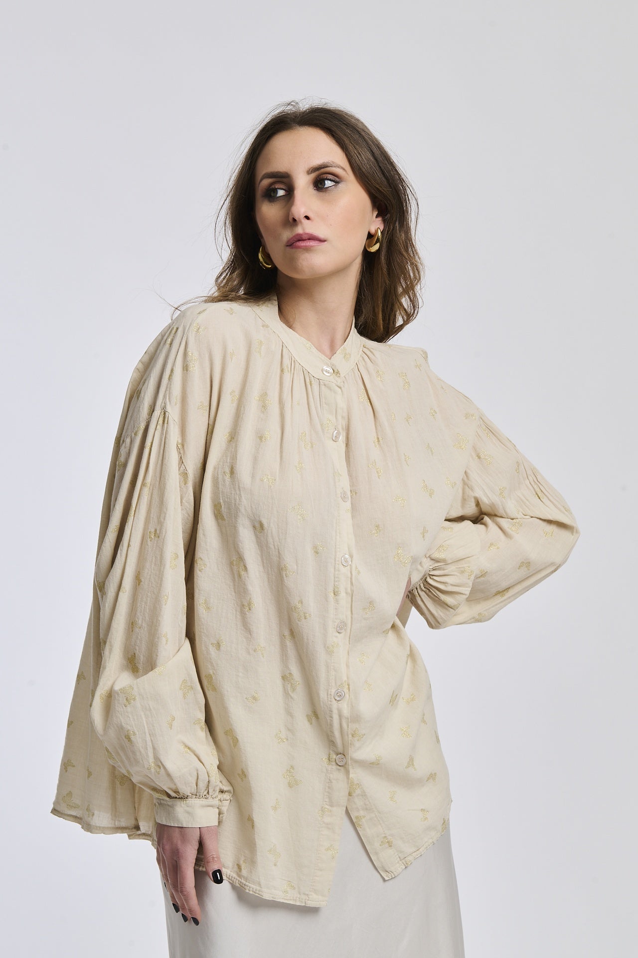 Outfit boho: Camicia beige stampata con collo a imbuto, abbinata a un gonna bianca fluida.
