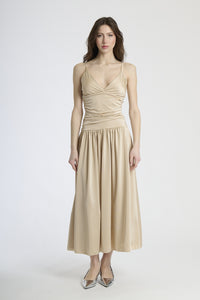 Moda donna: abito beige elegante, design con scollatura a V e gonna ampia.