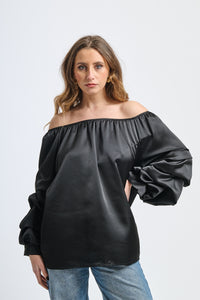 Blusa nera a spalla nuda, maniche ruffle, taglio oversize, stile iconico