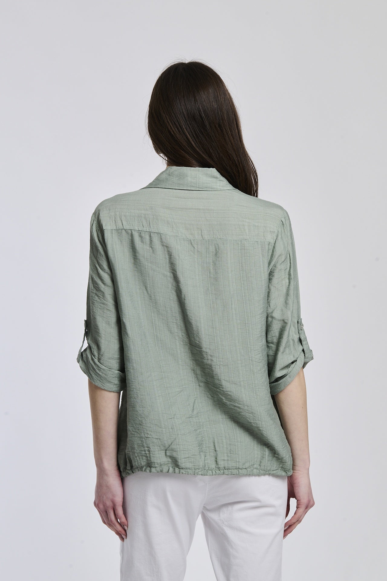 Donna indossa una camicia colore militare, con maniche regolabili, ideale per le giornate changeanti.