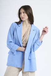 Donna elegante con blazer azzurro, stile sofisticato e moderno.